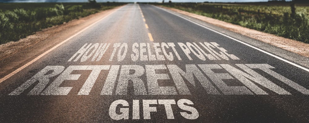 Country highway with the text HOW TO SELECT POLICE RETIREMENT GIFTS painted on the asphalt.